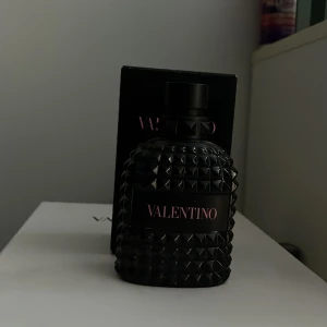 Valentino Uomo Born in Roma  - Säljer en flaska Valentino Uomo Born in Roma Eau de Toilette. Flaskan har en elegant design med nitar och svart färg, vilket ger en lyxig känsla. Perfekt för den som vill ha en sofistikerad och modern doft. Finns ungefär 50-60 ml kvar så priset kan diskuteras vid snabb affär!