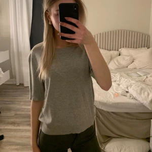 Grå tröja med trekvartsärm - Säljer en stilren grå tröja med trekvartsärm. Perfekt för en avslappnad look. Tröjan har en normal passform och är tillverkad i ett mjukt material.