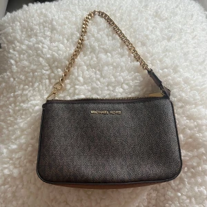 Michael Kors väska - Säljer en fin brun Michael Kors ”Jet set chain pouchette”. Köpt på Zalando för 1595kr. 🤎   Superfint skick, i princip som ny.  11 cm x 19 cm x 6 cm x 16 cm