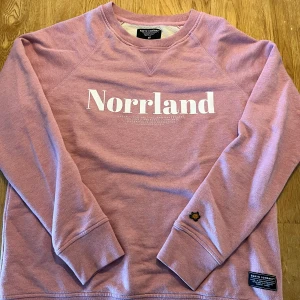 Rosa sweatshirt med Norrland-tryck - Säljer en rosa sweatshirt från SORTN COMPANY med Norrlands tryck. Den är i storlek XS men är i stor i storleken så passar S.