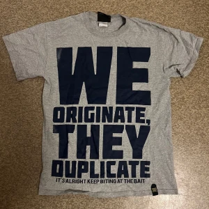 Grå t-shirt med tryck från Edukation Athletics - Snygg grå t-shirt från Edukation Athletics med stort tryck på framsidan. Gang Starr inspired logga