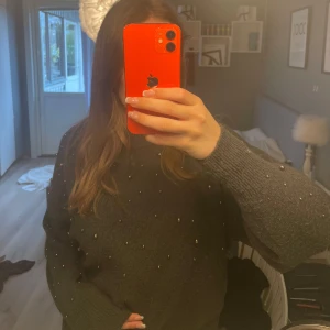 Mörkgrå stickad tröja med pärlor - Säljer en mörkgrå stickad tröja med pärldetaljer över hela framsidan. Ganska använd men ändå bra skick. Storlek S💕