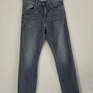 Grå jeans från Replay - Säljer ett par grå jeansbyxor från Replay med klassisk femficksdesign och raka ben. Byxorna har normal passform och är tillverkade i denim med snygg tvättad look. Perfekta till vardags för en avslappnad stil. Storlekslappen är bortklippt men det är storlek 14 år/158 cm. Köpta på Kids Brand Store