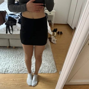 Miniskirt  - Svart minikjol i strl XS från Nelly. Skulle säga att den passar XS/S. Den går att vika ner utan att det syns om man vill ha den lite kortare, och ba ha som vanligt om man vill ha den lite längre (se bilder). Har aldrig använt kjolen, var bara snabb med att klippa av lappen:), så den är i helt nytt skick!🫶🏼 kom gärna med bud!