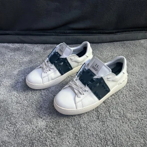 Valentino  - Säljer ett par vita Valentino Garavani sneakers i storlek 43. Skorna är i fint skick (8/10) | kommer med originalpåse | Ny pris cirka 7000kr |  Några nitar saknas, men det påverkar inte helhetsintrycket Pris kan diskuteras vid snabb och smidig affär!! 
