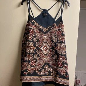 Mönstrat linne från River Island - Ett snyggt linne från River Island med tunna axelband. V-formad och perfekt nu när sommaren börjar närma sig💕