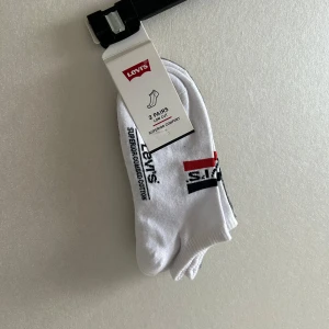 Levi's låga strumpor  - Säljer ett 2-pack låga strumpor från Levi's i vitt och grått. Strumporna har Levi's-logga undertill. De är helt nya och aldrig använda. I orginal förpackning💗