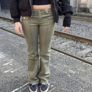 Gröna jeans - Säljer ett par olivgröna bootcut byxor med markerade sömmar och fickor framtill med knappar. Byxorna har låg midja. Perfekta för en trendig och avslappnad stil. Endast använda 2 gånger💕