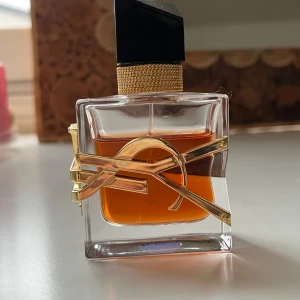 Yves Saint Laurent Libre Le Parfum  - Exklusiv parfym från Yves Saint Laurent, Libre Le Parfum, i en elegant fyrkantig glasflaska med guldiga detaljer och svart asymmetrisk kork. Doften är varm och intensiv, perfekt för dig som gillar lyxiga och moderna parfymer. Ursprungligen 30ml, har använt ca 5-7ml, så ca 25-23ml kvar💓
