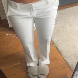Vita kostymbyxor med pressveck - Säljer ett par stilrena vita kostymbyxor med låg midja. De är från bikbok passar 36/38