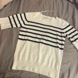 Vit och marinblå randig tröja från Kappahl - Säljer en vit tröja från Kappahl med marinblå horisontella ränder. Tröjan har rund halsringning, långa ärmar och är tillverkad i mjukt material. Perfekt för en stilren och klassisk look.