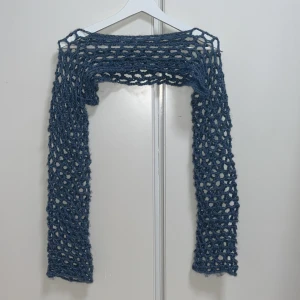 Blå virkad bolerotopp - Säljer en hand virkad blå bolerotopp av mig med öppet, nätliknande mönster. Perfekt att slänga över en topp för en cool lager-på-lager-look. Långärmad och supermjuk känsla.