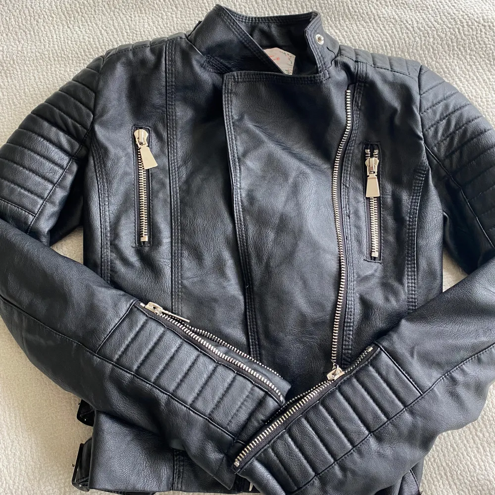 Säljer en svart skinnjacka från Voyelles i storlek 36. Jackan har coola quiltade detaljer på axlar och ärmar, flera dragkedjor framtill och vid ärmslut samt ståkrage. Personligen tycker jag den är mindre än en normal str 36, så passar nog en 34 bättre. . Takit.