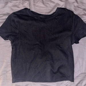 Svart ribbad croppad t-shirt från FSBN Sister - En svart croppad t-shirt från FSBN Sister i ribbat material. Köpt på New yorker, säljer för att den inte kommer till användning längre!🩷