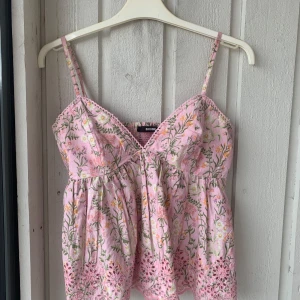Rosa blommig topp - Säljer en super gullig sommar topp från bilbok då den ej kommer till användning. Toppen är i nyskick då jag bara har använt den 2 gånger. Den säljs inte längre💖