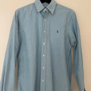 skjortor från Ralph Lauren - Säljer en klassiska skjortor från Ralph Lauren med button-down krage och broderad logga på bröstet. Skjortan har långa ärmar och vita knappar framtill. Perfekt för en stilren look. Säljer allt för 1000 kronor annars är det 200 kr st. Allt är ÄKTA