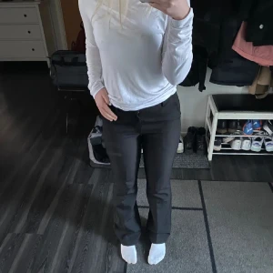 Svarta kostymbyxor  - Svarta kostymbyxor från Bik Bok med klassisk passform och bootcut-silhuett. Byxorna har hög midja, hällor för bälte och stängs med dragkedja och knapp. Perfekta för en clean och stilren look.