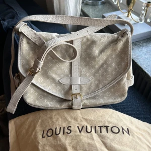 Louis Vuitton Monogram Mini Lin Canvas - Snygg beige axelväska från Louis Vuitton med klassiskt monogrammönster. Väskan har justerbar axelrem, guldfärgat spänne och detaljer i skinn. Tillverkad i bomullscanvas med präglad logotyp på insidan. Tillverkningsland Frankrike och pris diskuteras privat! Köpt från A Retro Tale för ett år sedan och väskan är i mycket bra skick.
