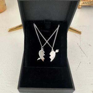 Arrow heart necklace  - Två matchande silverhalsband med delade hjärthängen – perfekta att dela med en vän eller partner. Halsbanden är 100 % rost- och nickelfria. Kedjorna är 40 cm långa men kan förlängas med ytterligare 5 cm. Hör gärna av dig om du har några frågor ☺️