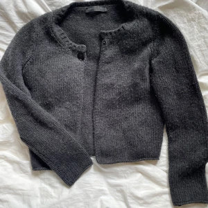 Mörkgrå kashmirkofta från Fabiana Filippi - Supermjuk och lyxig mörkgrå kofta i 100% kashmir från Fabiana Filippi. Klassisk rund halsringning, långärmad och med enkel knapp framtill💕💕nypris runt 4000 kr