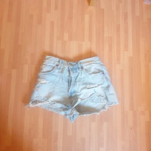 Ljusa jeansshorts från Zara - Snygga ljusblå jeansshorts från Zara med hög midja och slitna detaljer. Klassisk femficksmodell med råa kanter och avslappnad passform. Perfekta för sommardagar när du vill ha en chill och trendig look.