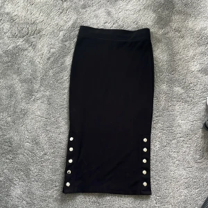 Svart långkjol med knappar från Amisu💗 - Svart långkjol från Amisu i snygg modell. Kjolen har silvriga knappar längs båda sidorna nertill och har väldigt bra skick, inte använd ofta. 💗