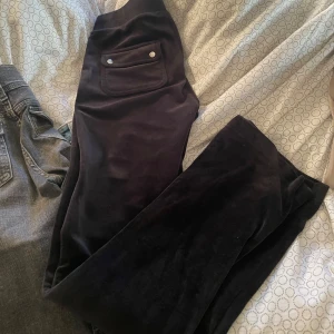 Svarta mjukisbyxor i sammet - Mörka svarta mjukisbyxor i mjuk sammet med bred resår i midjan och snörning framtill. Byxorna har fickor både fram och bak, varav bakfickan har två silvriga knappar. Perfekta för en chill och avslappnad stil.