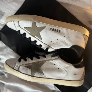 Golden Goose skor - Säljer nu dessa Golden goose skor i storlek 39 med svarta snören. Riktigt sjysst skick, men en liten skada på hälen som nu ser i bilderna. Tillkommer skor och en dustbag🙌👏