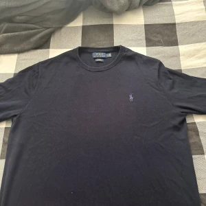  Polo Ralph Lauren tröja - Svart långärmad tröja från Polo Ralph Lauren i slim fit-modell. Tillverkad i mjuk pima bomull och har den klassiska broderade loggan på bröstet. Perfekt för dig som gillar stilrena och tidlösa plagg med premiumkänsla.