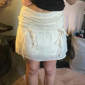 Vit minikjol med snörningar - Supersöt somrig minikjol med fina snöriningsdetaljer 