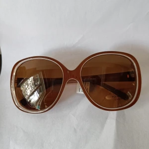 Bruna oversized solglasögon Pilgrim - Snygga oversized solglasögon från Pilgrim med bruna bågar och bruna tonade glas. Runda, retroinspirerade bågar i plast med dansk design. Glasen är polariserade och har UV400-skydd. Perfekta för att lyfta din stil i solen.