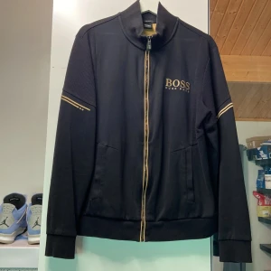 Hugo boss tröja  - Hugo boss tröja i storlek L. Tröjan är i bra skick och inte använd mycket. Finns täcken på slitage vid kragen samt ett litet märke på armen som syns i bild 4