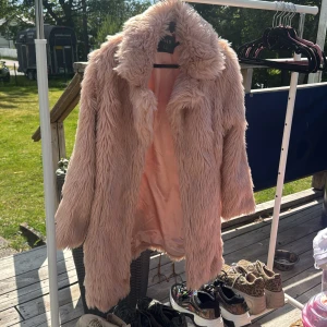 Ljusrosa pälsjacka från QED LDN - Fluffig och oversized ljusrosa pälsjacka från QED LDN. Jackan har lång lugg, bred krage och är helfodrad i satinigt tyg. Perfekt statement-plagg för dig som vill sticka ut och hålla dig varm med stil.