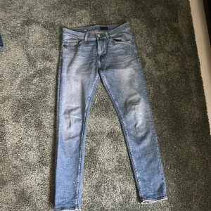 Ljusblå skinny jeans från Tiger of Sweden  - Säljer ett par ljusblå skinny jeans från Tiger of Sweden med klassisk femficksdesign och snygga slitningar. Jeansen har normal midja och smal passform hela vägen ner. Perfekta för dig som gillar en modern och clean look.