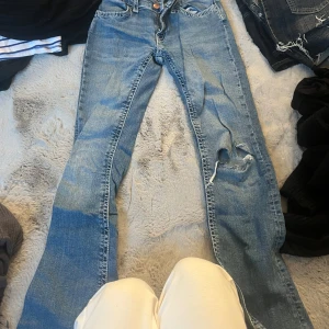 Blå jeans från Gina Tricot, storlek 164 - Säljer ett par klassiska blå jeans från Gina Tricot i storlek 164. Jeansen har en rak passform, normal midja och slitning med hål på ena benet för en cool, avslappnad look. Perfekta till sneakers och hoodie. om ni vill se fickorna hör av er