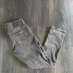 Grå jeans från Jack & Jones Slim Glenn - Säljer dessa oerhört snygga och trendiga Jack and Jones jeansen i storlek 32. Skick 10/10. Nypris 800:-  vårt pris 199:- Endast jeansen medföljer. Passar mellan 175-185 ish, priset kan eventuellt diskuteras vid snabb affär! Kom med bud!