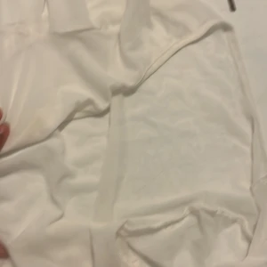 Vit långärmad topp från SHEIN - Vit långärmad topp från SHEIN i storlek S. Tunt och lätt material, troligen polyester, med enkel design och rund hals. Perfekt för lager-på-lager eller till ett par jeans. Snygg basic som funkar året runt. Funkar också perfekt att ha till stranden  och den kan även knytas.