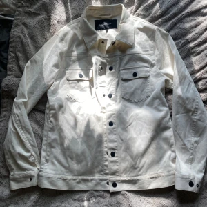 Vit jeansjacka / overshirt från Martinique - Köpt på samplesale men har aldrig använts! Snygg vit jeansjacka/overdhirt från Matinique med svarta knappar och klassiska bröstfickor med lock. Jackan har rak passform, krage och är tillverkad i bomull. Perfekt att dra över vad som och få en lite mer klädd look. 