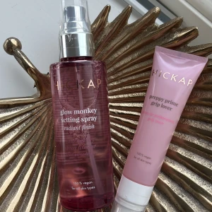 Hickap setting spray & primer duo - Hickap Glow Monkey Setting Spray i  rosa flaska med pump och Preppy Prime Grip Lover primer i ljusrosa tub. Båda är 100% veganska och passar alla hudtyper. Perfekt för att få sminket att sitta och ge glow. Går att köpa separat eller båda för 245kr