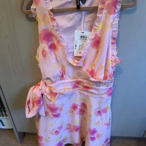 Blommig kortklänning från Vero Moda - Nu så säljer jag denna supersöta kortklänning från Vero Moda med blommigt mönster i rosa och gult. Den har en djup v-ringning med volangkant, tajt midja och en rosett i sidan som man kan knyta som man själv vill! Köpt förra sommaren för 599kr men helt oanvänd med prislappen kvar pga att det inte kommit ett tillfälle att använda den tyvärr. Vid intresse är det bara att höra av sig till mig☺️