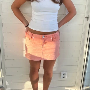 Jeanskjol korall - Jeanskjol som är korall/orange, storlek 34. Har lite slitage vid knappen skriv provet för bilder.