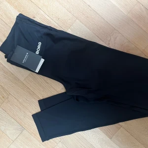 Svarta tights från Björn Borg - Svarta tights från Björn Borg med logga på höften. Snygg och sportig modell i stretchigt material, perfekta för träning eller gym. Tight passform och bekväma att röra sig i.