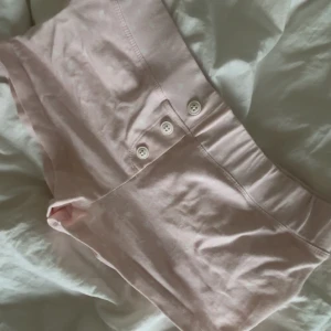 Ljusrosa pyjamas shorts - Säljer ett par ljusrosa shorts från Gina Tricot med vita detaljer och bred resår i midjan. Shortsen har dekorativa knappar framtill och är tillverkade i mjuk bomull. 💕💕