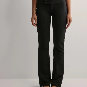 Svarta kostymbyxor från Nelly - Säljer ett par svarta kostymbyxor från Nelly med två knappar i midjan. Skitsnygga och helt nya, säljer pga att jag köpte Xs eftersom jag kände att dem var lite för tajta. Satt bra i längd🩷🤍 org pris 349kr