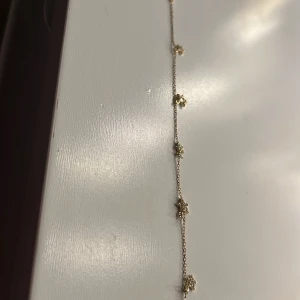 Guldfärgat armband med stjärnberlocker - Säljer ett tunt och elegant armband i guldfärg med små stjärnformade berlocker. Perfekt för dig som gillar diskreta men fina detaljer. Stjärnorna har små glittrande stenar som ger extra lyster.