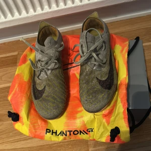 Nike Phantom GT2 fotbollsskor orange - Säljer ett par Nike Phantom GT2 fotbollsskor i färgen orange. Dom är smutsiga men har bra grepp och dubbarna är nästan som nya.Smuset går bort om man tvättar dom. Pris kan diskuteras 