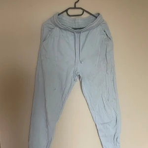 Ljusblå mjukisbyxor från Aware by Vero Moda - Ljusblå mjukisbyxor med resår i midjan och dragsko, från Aware by Vero Moda. Byxorna har avslappnad passform och muddar vid bensluten. Perfekta för en chill och bekväm stil.💙 några små fläckar som ej går bort 