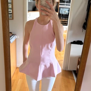 Zara topp  - Säljer en ljusrosa halterneck topp med peplumskärning. Den är öppen i ryggen och helt oanvänd med prislapp kvar. Säljer då den är för lång för mig som är 156 i storlek xs🩷