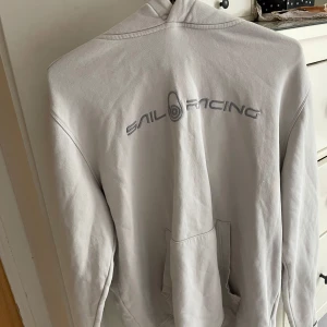 Vit hoodie från Sail Racing - Vit hoodie från Sail Racing, kommer ej till användning säljes för billig peng. Skriv vid fundering!
