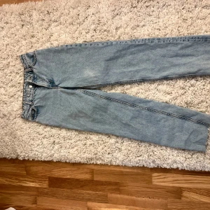 Ljusblå raka jeans från Monki - Säljer ett par ljusblå jeans från Monki i rak modell. Jeansen har klassisk femficksdesign, normalhög midja och är tillverkade i 100% bomull för en äkta denimkänsla. Perfekta för en chill och avslappnad stil.